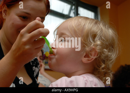 Kleinkind Babynahrung von ihrer Mutter gefüttert Stockfoto