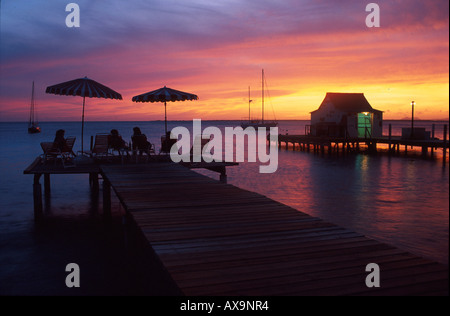 Menschen, die einen romantischen Sonnenuntergang von Holzsteg, Divi Flamingo Beach Resort, Bonaire, ABC-Inseln, Niederländische Antillen, Ant Stockfoto