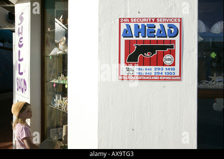 Kind auf der Suche in einem Souvenir Shop Fenster Warnung Zeichen, Jeffreys Bay, Eastern Cape, Südafrika, Afrika Stockfoto
