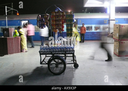 Die surreale Unschärfe, die durch nächtliche Bewegung um einen Verkäuferwagen auf dem Bahnsteig am Bahnhof Hyderabad, Telangana, Indien, verursacht wurde. Stockfoto