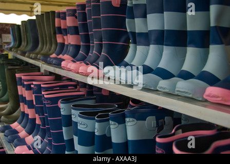 Zeilen der Gummistiefel für den Verkauf auf einen Stand auf einem Land zeigen Stockfoto