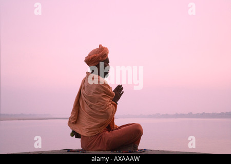 Heiliger Mann meditieren am Ufer Flusses Ganges Varanasi Indien Stockfoto