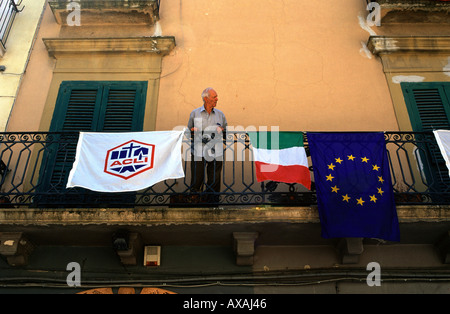 Älterer Mann mit italienischer Flagge winken neben der EU-Flagge in der alten Stadt von Bari Süditalien Stockfoto