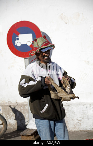 Straße Verkäufer Mann Verkauf von Hai Kiefer in Agadir, Marokko. Er trägt einen Hut und hoodie Stockfoto