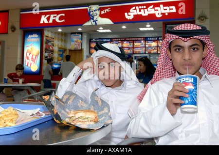 Katar Kinder in traditionellen Outfits Fastfood in einem Einkaufszentrum in Doha. Stockfoto