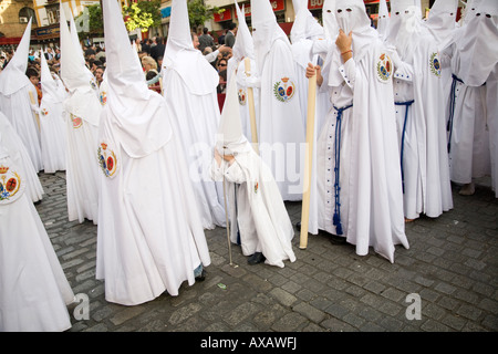 Eine junge Büßer stützte sich auf einen Stock während einer Prozession der Karwoche, Sevilla, Spanien Stockfoto