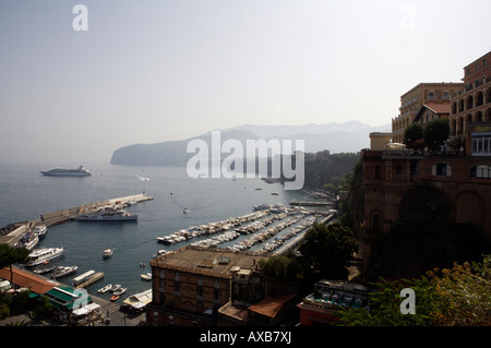 Ein Blick auf den Hafen von Sorrent mit einem Kreuzfahrtschiff in den Hintergrund und verschiedenen Hotels, Boote und Yachten im Vordergrund Stockfoto