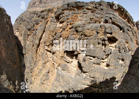 Vier Bergsteiger in den Schatten gestellt durch die Klippen von Snake Canyon in Jebel Akhdar der westlichen Hajar-Gebirge im Oman. Stockfoto