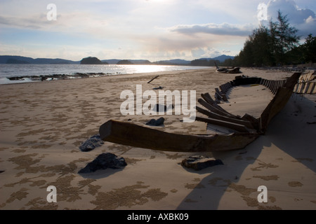 Boot-Skelett auf Thai Strand bei Sonnenuntergang Stockfoto