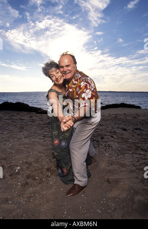 Älteres paar tanzen am Strand, lächelnd, Sonnenuntergang, Connecticut, USA. MR-9-5-02-2; MR-9-5-02-1 Stockfoto