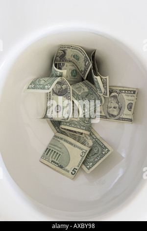 Flushing Geld in die Toilette Stockfoto