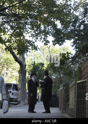 Jüdische Männer in Tracht im Chat auf den Bürgersteig, USA, Brooklyn, New York Stockfoto