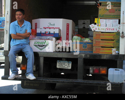 Mann sitzt auf der Ladefläche des LKW in SoHo neben Gemüse, USA, Manhattan, New York Stockfoto