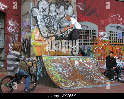 Jugendliche BMX-Fahrrad fahren auf Rampe vor Wand mit Graffiti unter der Manhattan-Bridge, USA, Manhattan, New York Stockfoto