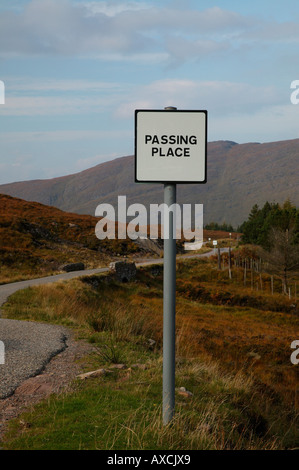 Zeichen für die Weitergabe mit Bergen und geschwungene Straße im Hintergrund Torridon, Wester Ross, Schottland, Europa statt. Stockfoto