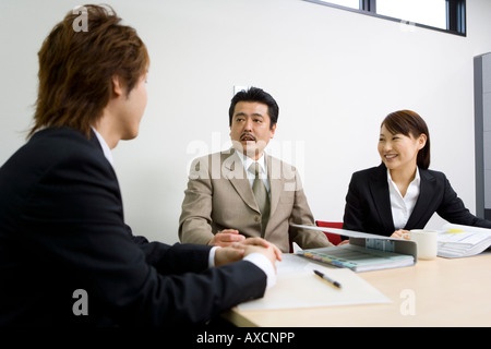 Drei Personen diskutieren im Tagungsraum Stockfoto