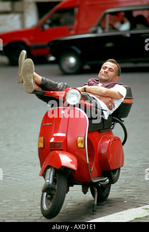 Europa Italien Rom Piazza Navona, ein junger Mann schläft auf seinem roten Motorroller Motorrad Vespa entspannt, zurücklehnen ruhenden Stockfoto