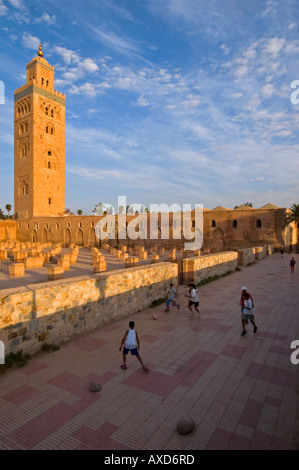 Senkrechten Blick auf die Koutoubia-Moschee mit jungen Fußball spielen im Vordergrund auf einem sonnigen Abend. Stockfoto