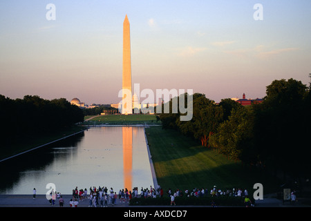 Touristen am Rand des Widerspiegelnder Teich sehen Washington Monument und dem US Capitol Building auf der Washington Mall bei Sonnenaufgang Washingt Stockfoto
