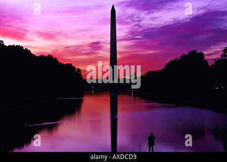 Fotograf mit Stativ steht am Rand des reflektierenden Pool machen Bild von Washington Monument und Widerspiegelnder Teich bei Sonnenaufgang Stockfoto