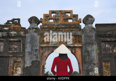Mädchen in Ao Dai traditionelle vietnamesische langes Kleid und konische Hut in kaiserliche Stadt Hue, Vietnam Stockfoto