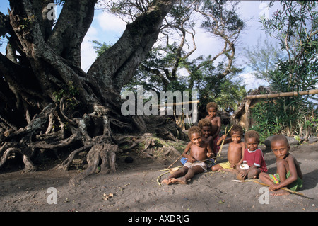 Melanesische Kinder sitzen zusammen unter einem Banyan Baum, Sulphur Bucht, Insel Tanna, Vanuatu Stockfoto