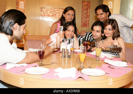 Junger Mann nehmen Foto von seinen Freunden in einem restaurant Stockfoto