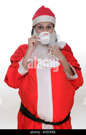 Porträt einer Frau Weihnachtsmann-Kostüm und Tee trinken Stockfoto