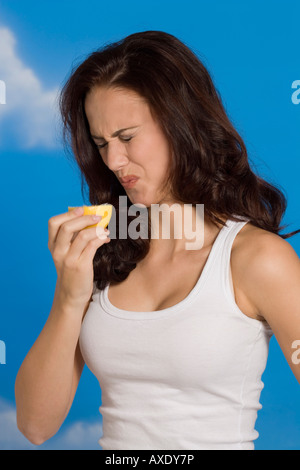 Junge Frau Grimasse, hält die Hälfte der Zitrone, Porträt Stockfoto