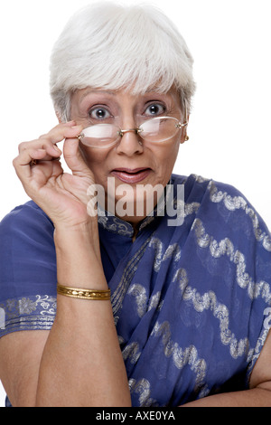 Portrait einer älteren Frau peeking über Brillen Stockfoto