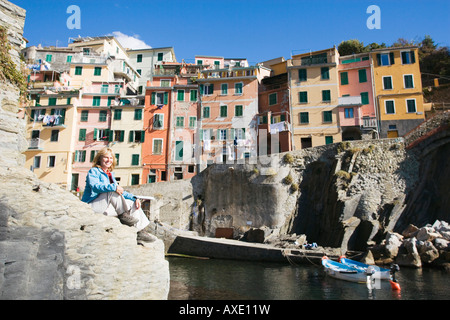 Italien, Ligurien, Riomaggiore, Frau sitzt auf Felsen Stockfoto