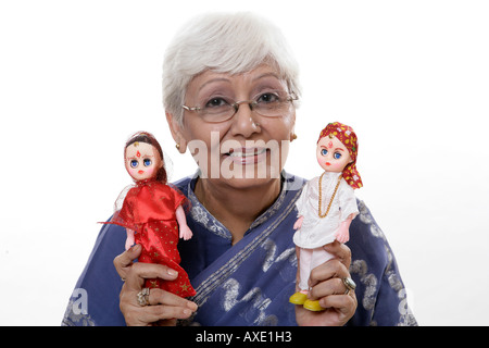 Porträt einer älteren Frau zeigen Puppen von Braut und Bräutigam Stockfoto