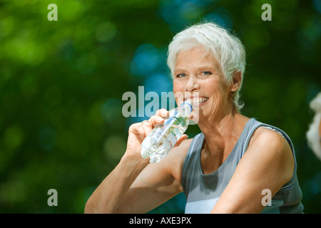 Ältere Frau, trinken aus der Flasche Wasser, Porträt Stockfoto