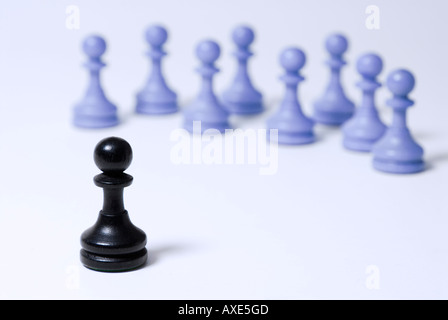 Schach, steht einem schwarzen Bauern vor einer Gruppe von blauen Bauern, Symbol für soziale Ausgrenzung, Konfrontation Stockfoto