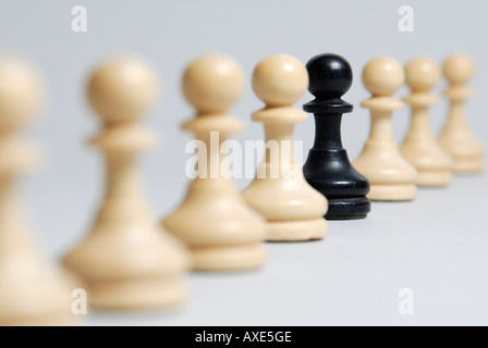 Schach, steht einem schwarzen Bauern in einer Reihe von weißen Bauern, Symbol für die soziale Integration, Beeing verschiedene Stockfoto