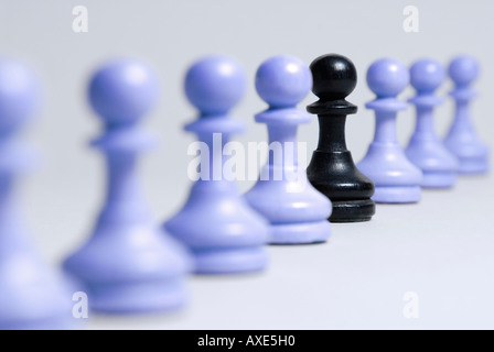 Schach, steht einem schwarzen Bauern in einer Reihe von blauen Bauern, Symbol für die soziale Integration, Beeing verschiedene Stockfoto