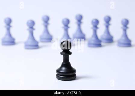 Schach, steht einem schwarzen Bauern vor einer Gruppe von blauen Bauern, Symbol für soziale Ausgrenzung, Konfrontation Stockfoto