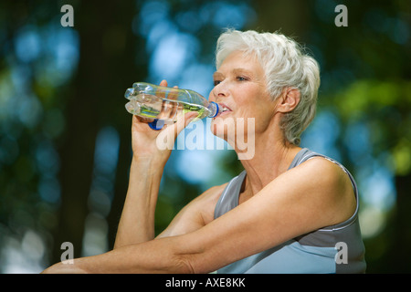 Ältere Frau, trinken aus der Flasche Wasser, Porträt Stockfoto