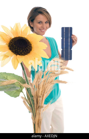 Frau mit Solarzellen, Sonnenblumen im Vordergrund Stockfoto