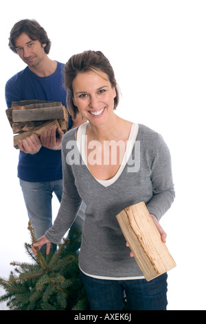 Paar mit Weihnachtsbaum und Brennholz Stockfoto