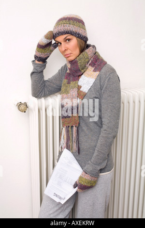 Frau mit Rechnung eines Versorgungsunternehmens, Schal und Mütze tragen Stockfoto