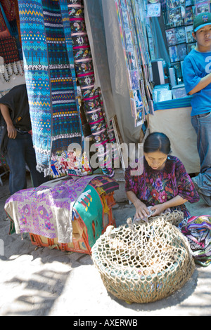 GUATEMALA CHICHICASTENANGO lokale Frau in traditioneller Kleidung verkaufen lebende Hühner aus einem Korb auf der Straße Stockfoto