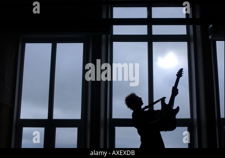 Ein kleiner Junge eine e-Gitarre zu spielen, Klang, Geräusch und Musik Bildung in einem Klassenzimmer der Schule zu illustrieren. Stockfoto