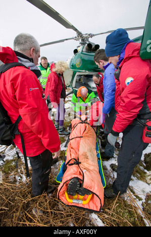 Mitglieder der Bergrettung Langdale Ambleside und eine Luft-Krankenwagen-Arzt zu evakuieren ein verletzter Wanderer Stockfoto