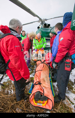 Mitglieder der Bergrettung Langdale Ambleside und eine Luft-Krankenwagen-Arzt zu evakuieren ein verletzter Wanderer Stockfoto