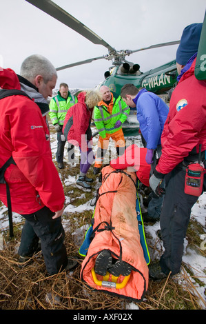 Mitglieder der Bergrettung Langdale Ambleside und eine Luft-Krankenwagen-Arzt zu evakuieren ein verletzter Wanderer Stockfoto