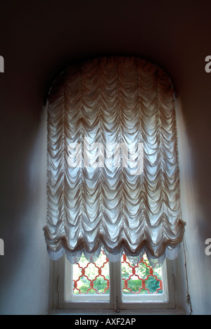 Sonnenlicht durch ein Fenster mit alten altmodischen net Stil Vorhänge bedeckt Stockfoto