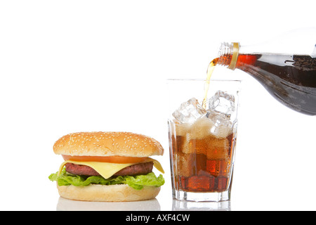 Cheeseburger mit Salat und Tomate und gießen Natron in ein Glas mit Eiswürfeln reflektiert auf weißem Hintergrund Stockfoto