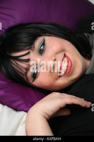 Glücklich Teenager auf Bett liegend Stockfoto