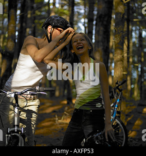 Zwei Mädchen auf dem Fahrrad posiert im Wald Stockfoto